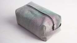A silver hand-sewn Dopp kit bag made in Ashley Nickel's Creativebug class.