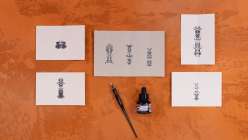 Five small pieces of paper with vertically oriented Rorschach-style illustrations plus a nib pen and acrylic ink.