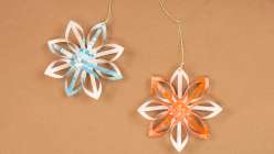 Two woven paper stars, one cream and teal, one cream and orange, from Dawn M. Cardona's Woven Paper Star Creativebug class 