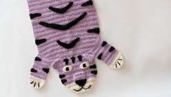 An lavender-colored crocheted rug in the shape of a tiger, made in Twinkie Chan's Crochet a Wild Animal Rug class on Creativebug