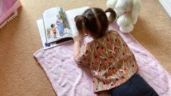 An overhead image of a toddler with pigtails wearing a shirt made in Cal Patch's Hand Sew a Shirt Creativebug class