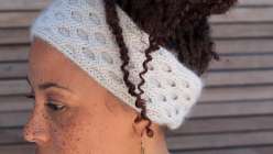 A close-up of a woman wearing a honeycomb cabled knit headband.
