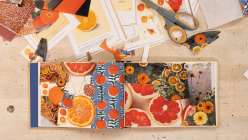 An overhead image of a two-page book spread featuring collage and drawn images of grapefruit and citrus from Creativebug's Altered Books Daily Practice class