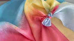A close-up image of a knotted silk play cape from the Easy Dyed Silk Play Cape class by Melissa Lang Lytle on Creativebug