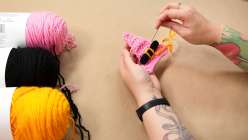 Hands assembling a crocheted witch hat from Twinkie Chan's Crochet Halloween Appliques class on Creativebug