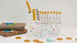 Unicorn menorah crafted from cardboard and clothespins made in Suzy Altman's Sustainable Play: Holiday Crafts class on Creativebug