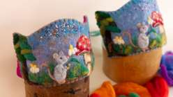 A felted kid's crown featuring the image of a mouse, clouds, and a mushroom made by Melissa Lyttle in her Wool Felting: Make a Woodland Celebration Crown class on Creativebug