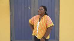 Tian Conaughton wearing a two-color crochet cardigan made in her Creativebug class, Crochet the Reignbow Vest

