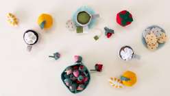 A selection of felt food including strawberries, oranges, and cookies, plus four mugs of tea, all made in Sanae Ishida's Sew Felt Play Food class on Creativebug.