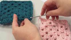 Two granny squares being joined together with a crochet hook in Twinkie Chan's 