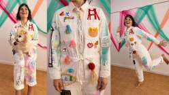 A colorful white jumpsuit embellished with tassels, hand-carved stamps, embroidery, painting, and drawings, made by Risa Iwisaki Culbertson in her class Wearable Wins on Creativebug