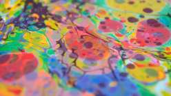 A close-up image of a piece of paper that wit two applications of marbling, made by Mercedez Rex in her Overmarbling On Paper class on Creativebug.