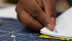 Sarah Matthews inserting a screw post into a notepad in her Make a Block Printed Notepad class on Creativebug.